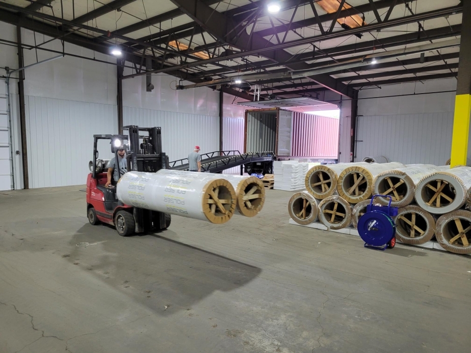 Truck kör med rullar på ett lager.